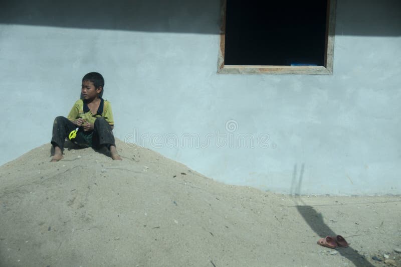 Child sitting outside his house in Laos. royalty free stock photo Child sitting outside his house in Laos. royalty free stock photo