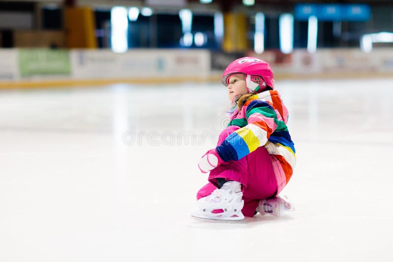 Child skating on indoor ice rink. Kids skate