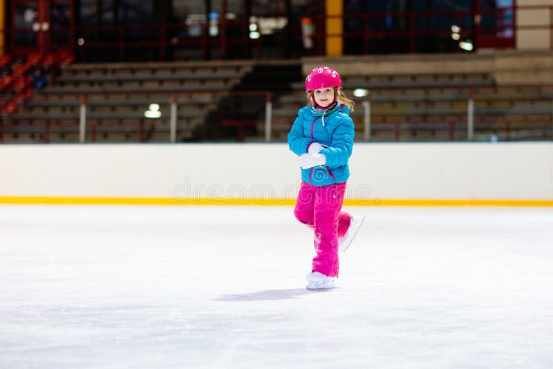 Child skating on indoor ice rink. Kids skate