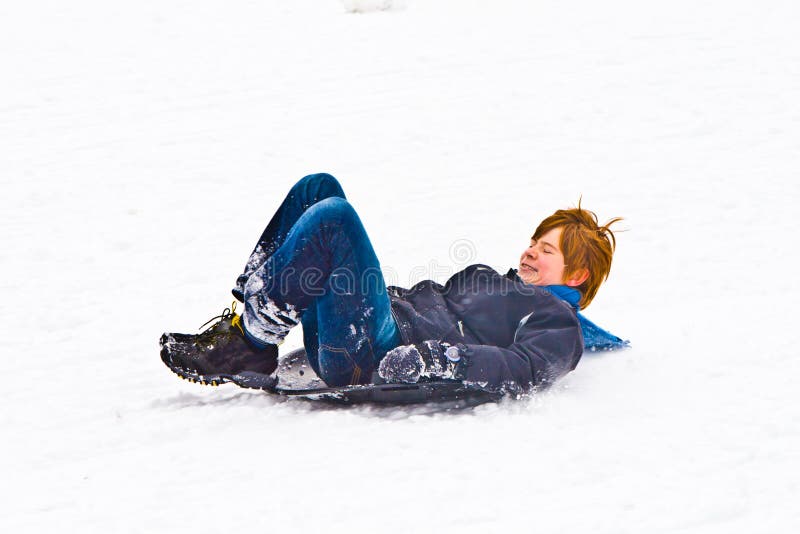 Child sledging down the hill in snow