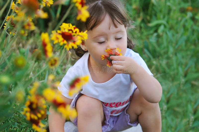 The child a smelling flower