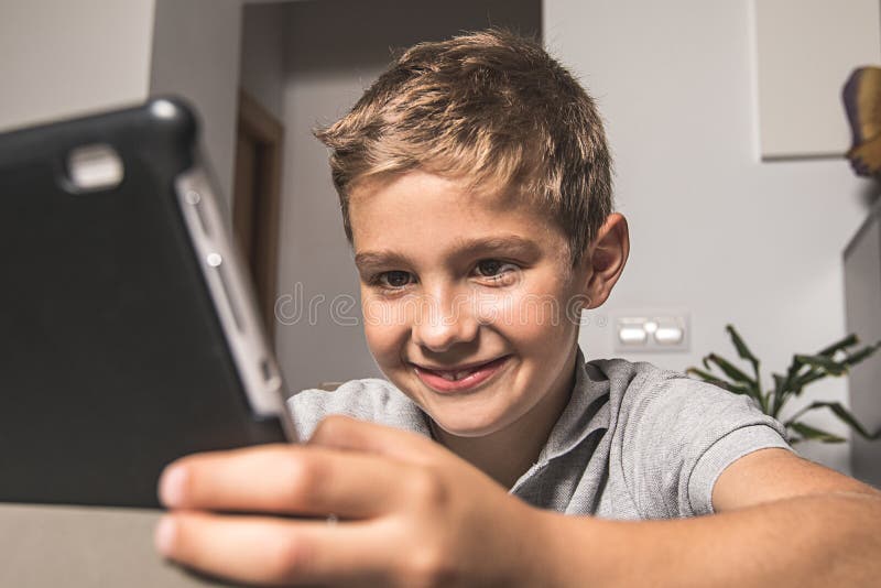Boy Looking Surprised Looking at a Tablet at Home. Child Looking at a ...
