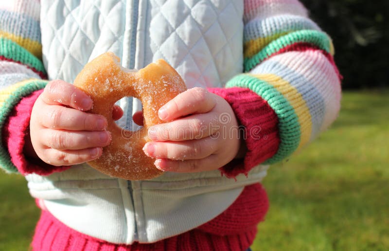 Child snacking on unhealthy chocolate donut