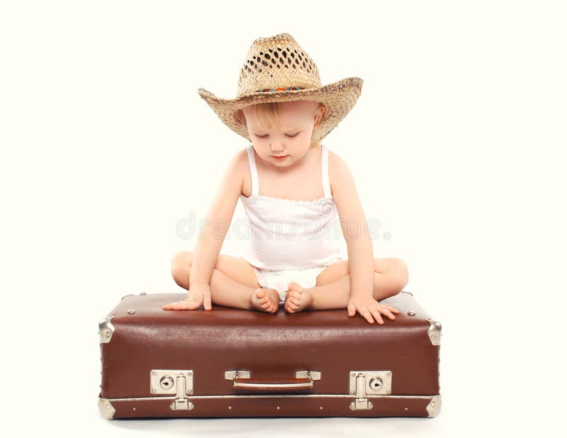 Child in a straw summer hat sitting on the suitcase stock photos Child in a straw summer hat sitting on the suitcase stock photos