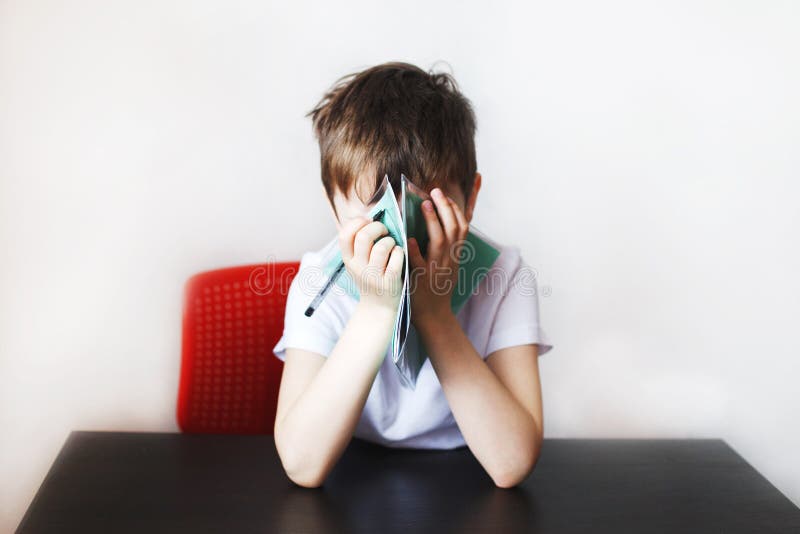The child is studying. the boy is tired of doing homework. royalty free stock photography