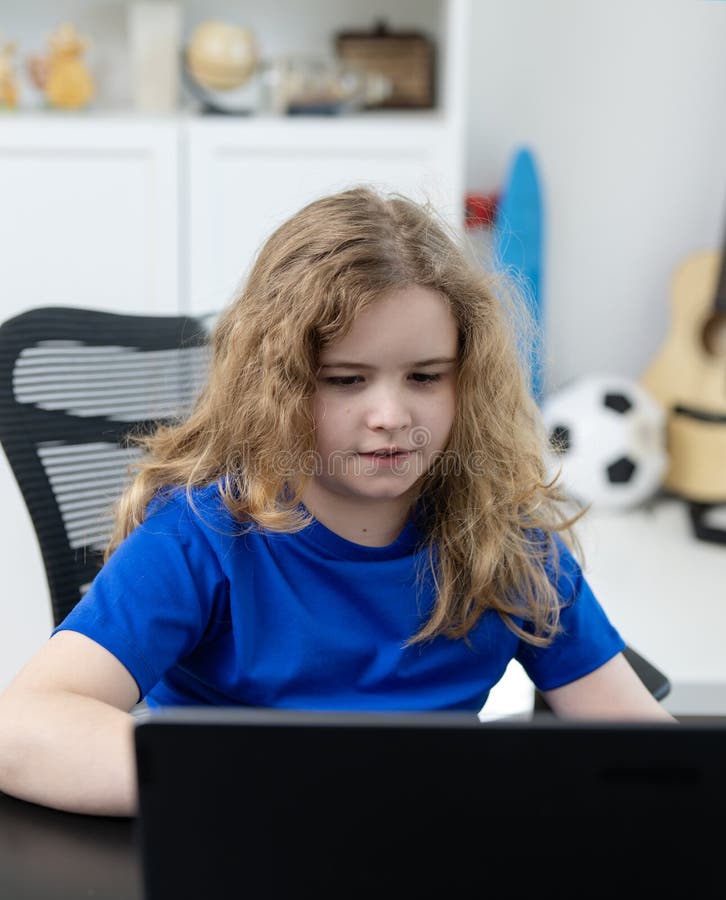 Child studying online school lesson. Student typing during school class. Boy focused on digital school work. Child watching online. School lesson royalty free stock photo