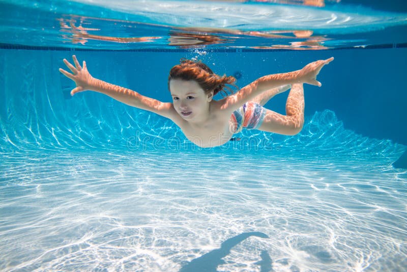 Child Swim Underwater in Pool. Kid Boy Swimming and Diving Underwater ...