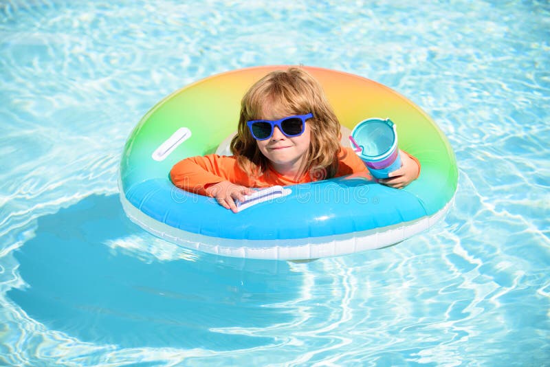 Child in swimming pool on inflatable ring. Little boy learning to swim with float. Water toy for toddler. Healthy