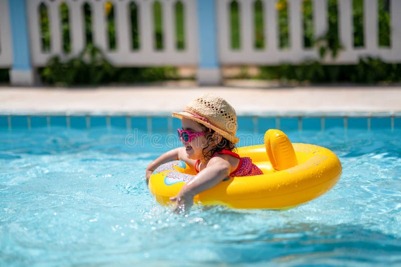 Child In Swimming Pool with ring. Summer Vacation With Kids.