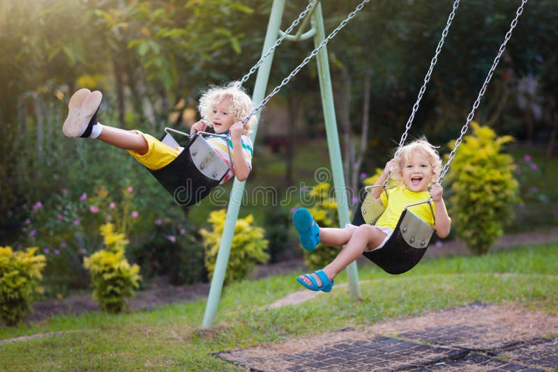Child swinging on playground. Kids swing