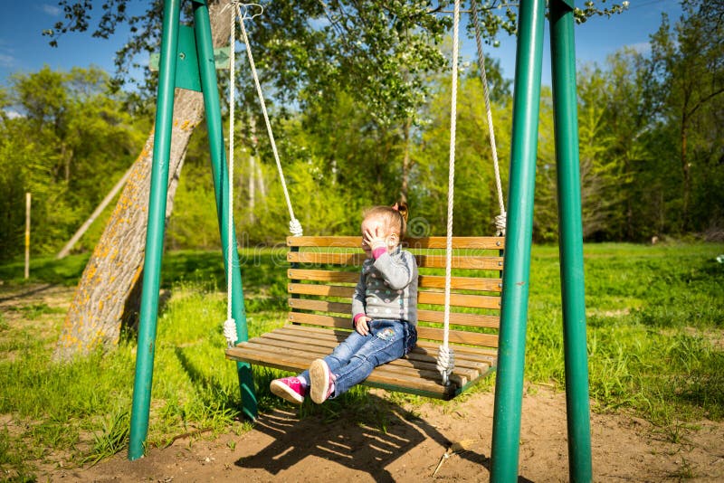 Child Swinging a Swing. Child Sitting on a Swing Stock Image Image of