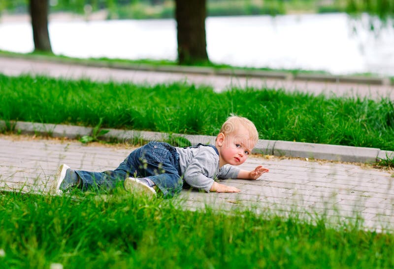 Child try to stand up after falled down in the park stock images Child try to stand up after falled down in the park stock images