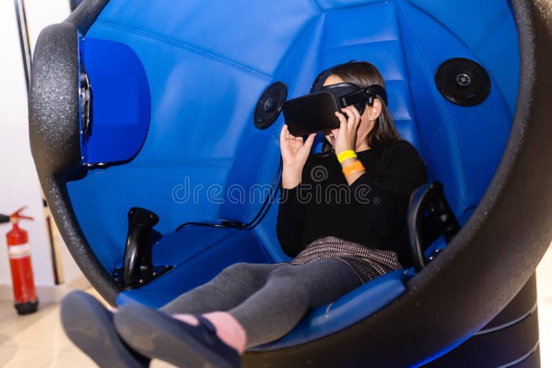 Child with Virtual Reality Headset Sitting in a Chair Booth Stock Image