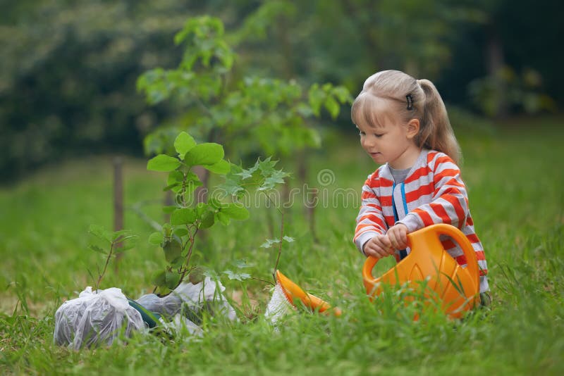 Bambino con l'acqua al di fuori di irrigazione appena piantato un albero.