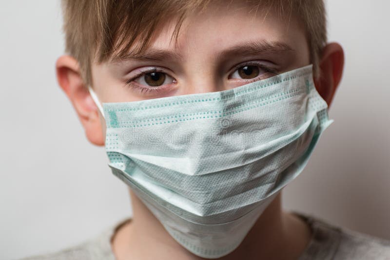 Child wears protective medical mask to protect him from Coronavirus. Boy with medical mask on his face royalty free stock photo Child wears protective medical mask to protect him from Coronavirus. Boy with medical mask on his face royalty free stock photo