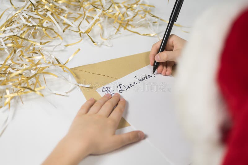 Child writes letter to Santa in santa`s hat. Christmas concept royalty free stock image Child writes letter to Santa in santa`s hat. Christmas concept royalty free stock image