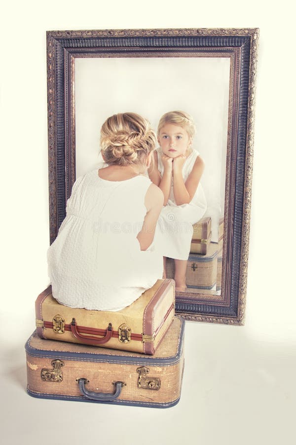 Child or young girl staring at herself in a mirror