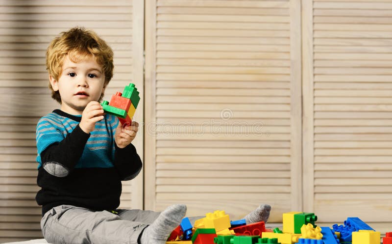 Childhood and educational activities concept. Boy plays with lego