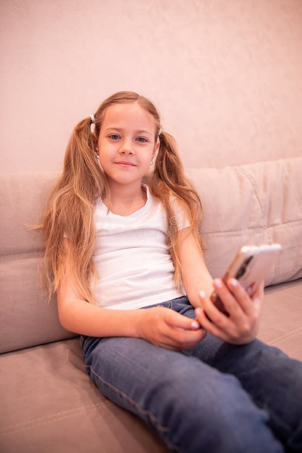 Childhood and Technology. the Girl Looks at the Phone. the Child Takes ...