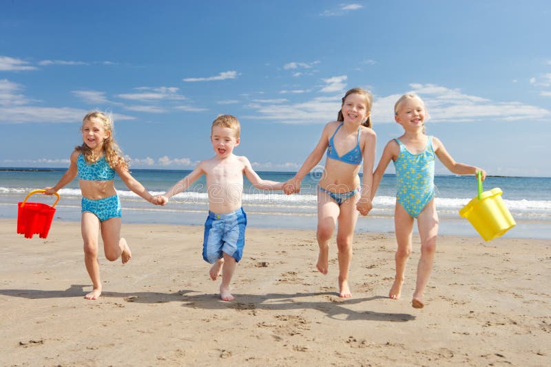 Kinder am Strand, im Urlaub laufen in Richtung Kamera.