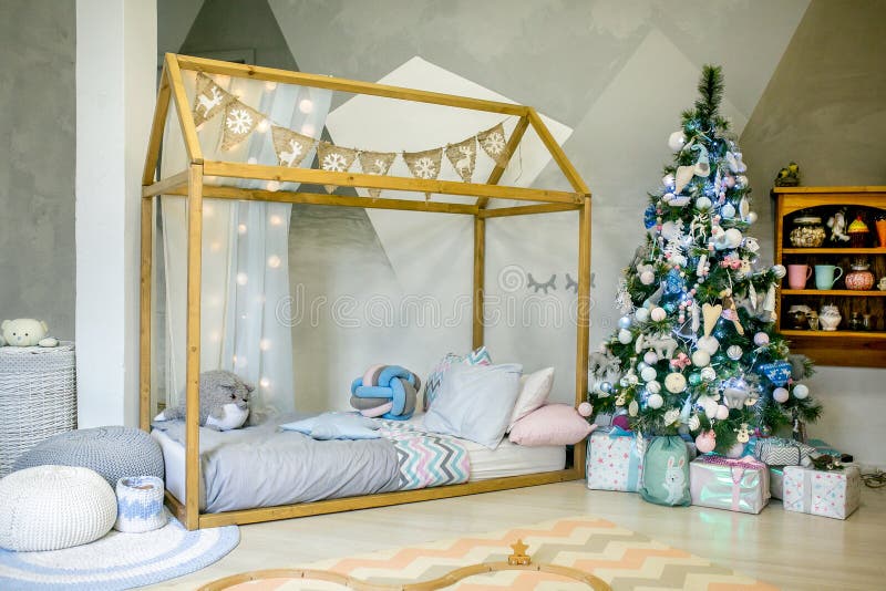 Children bedroom decorated for Christmas. Big wooden frame bed with pillows and plush toys, Christmas tree with balls, ribbons and stock photo Children bedroom decorated for Christmas. Big wooden frame bed with pillows and plush toys, Christmas tree with balls, ribbons and stock photo