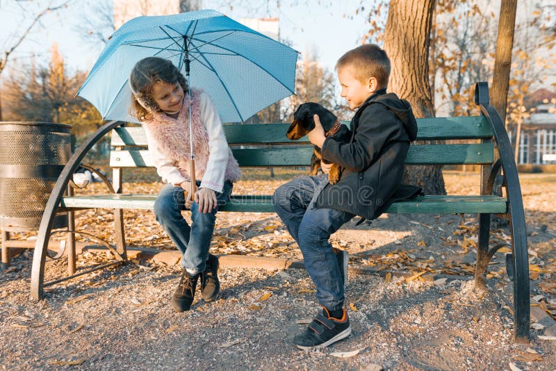 Childhood best friends. Дети беседуют на лавочке. Фото семьи на лавочке с собакой. Children sitting on a Bench in the Park. Семья с детьми и собакой сидит на лавке.