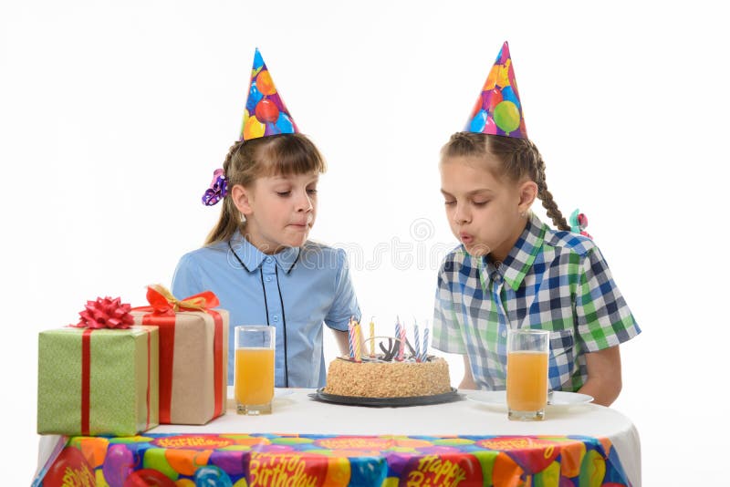 Children blow out candles on a birthday cake