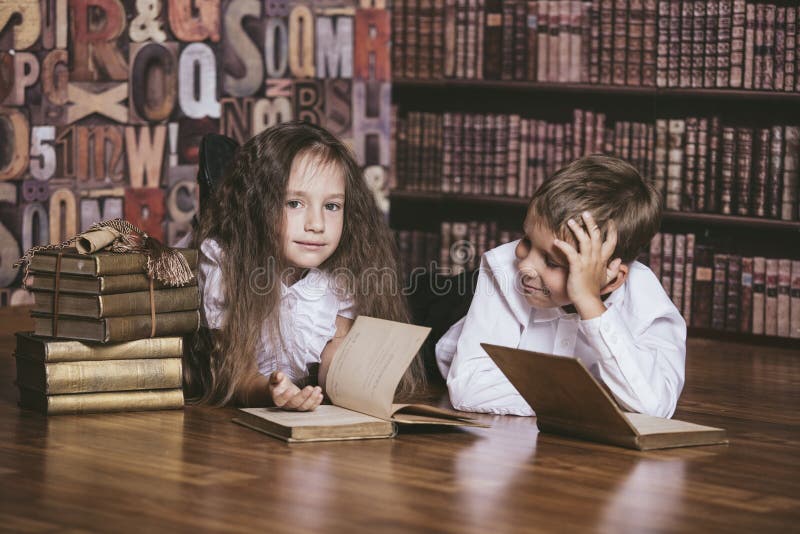 Children boy and girl children reading books in library