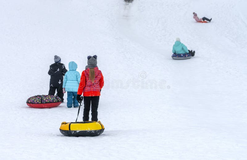 Children in colorful garments slide down the slide on inflatable rings stock photography Children in colorful garments slide down the slide on inflatable rings stock photography