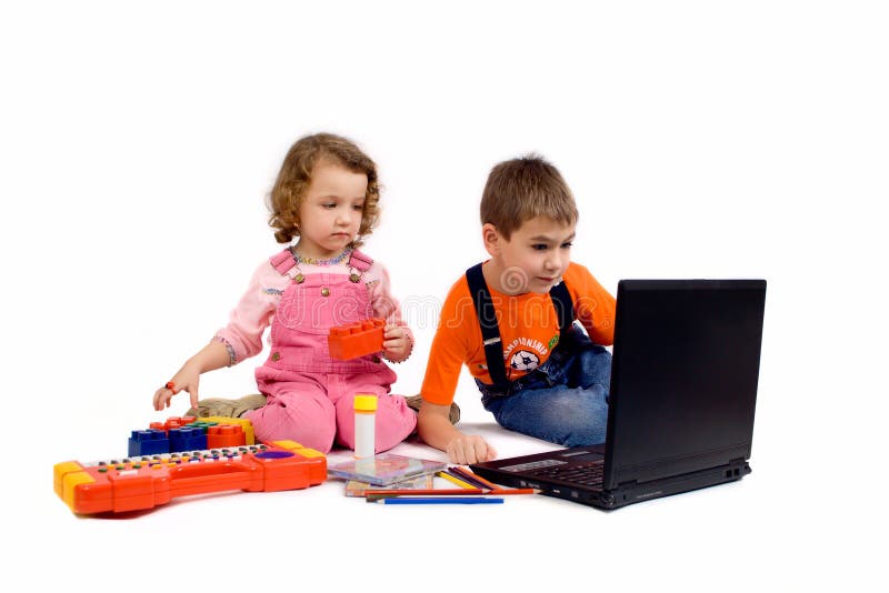 Children with the computer. Pencils, CD, school writing-materials around Children with the computer. Pencils, CD, school writing-materials around