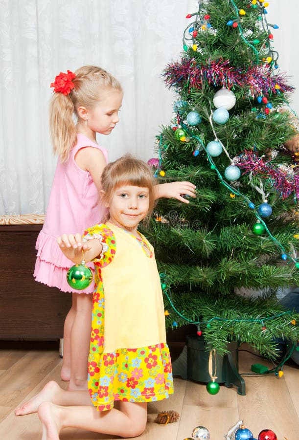 Children decorate the Christmas tree stock images