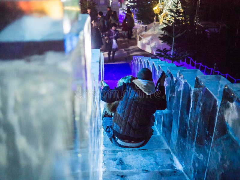 Children descend ice slide in Ice Palace, Winter Wonderland, London