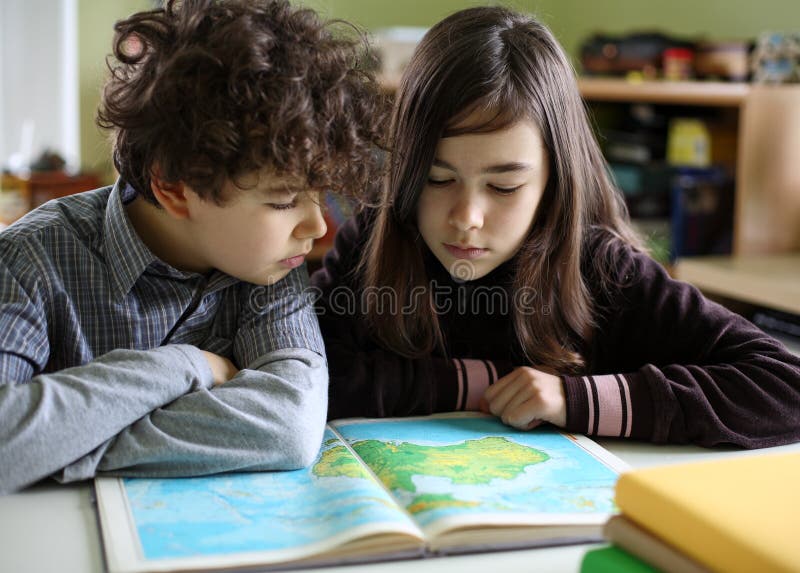 Girl and boy learning at home. Atlas book stock images, royalty-free photos and pictures
