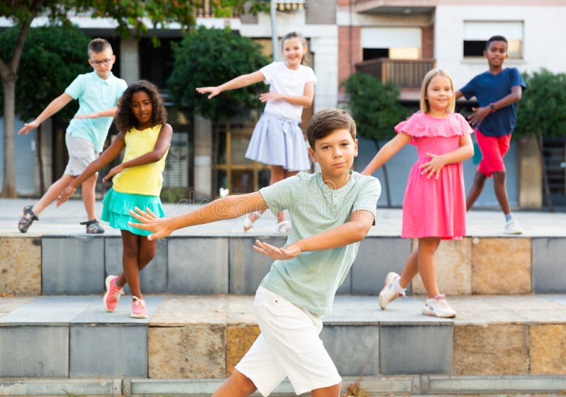 Children exercising contemporary dance moves outdoors