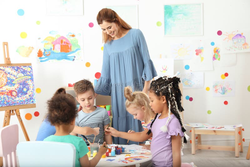 Children with female teacher at painting lesson stock photos Children with female teacher at painting lesson stock photos