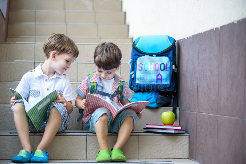 Children go back to school. Start of new school year after summer vacation. Two Boy friends with backpack and books on first schoo