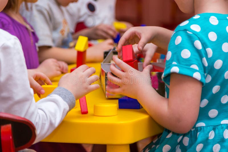 Children hands building towers out of wooden bricks