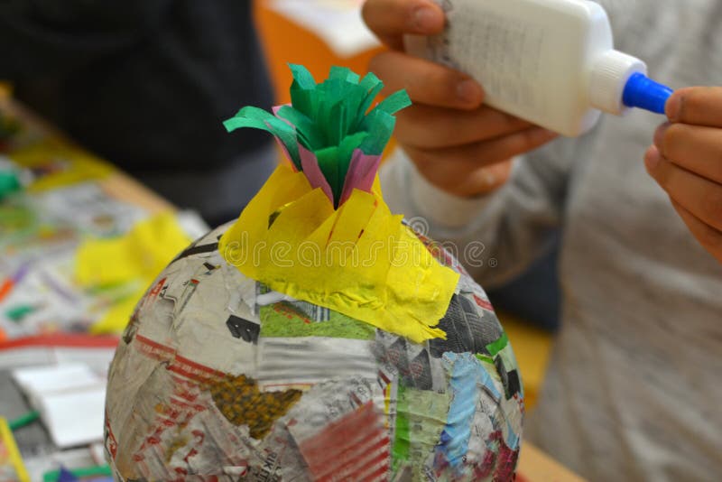 Children hands are making a pinata with colorful paper and glue. Children hands are making a pinata with colorful paper and glue.
