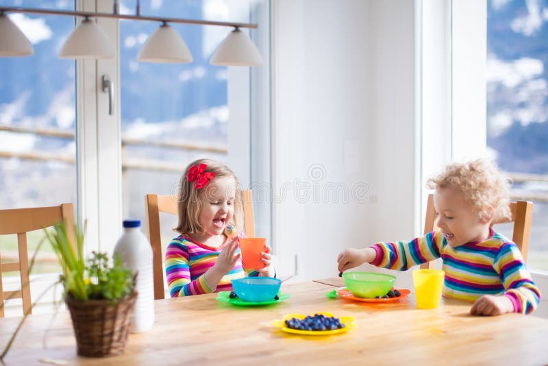Children having breakfast in sunny kitchen