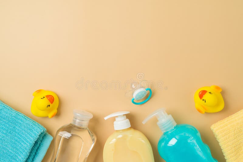 Children health care products on modern background. Baby shampoo, oil, soap, duck toys and towel. Top view, flat lay stock images