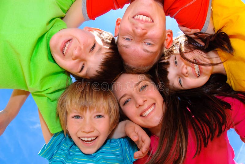 Children hugging. Happy children hugging in a circle against blue sky Children hugging. Happy children hugging in a circle against blue sky