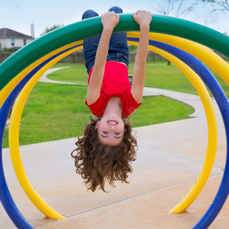 Children kid girl upside down on a park playground ring game. Children kid girl upside down on a park playground ring game