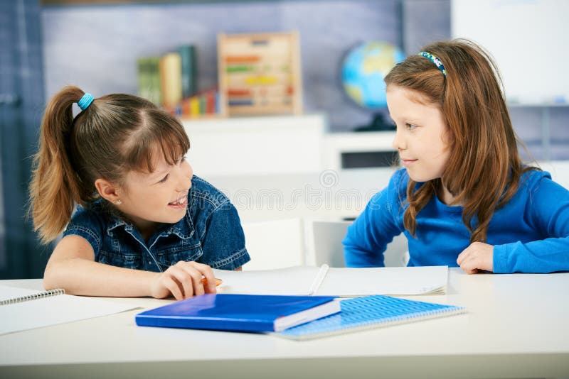 Schoolgirls learning together in primary school classroom. Elementary age children. Schoolgirls learning together in primary school classroom. Elementary age children.