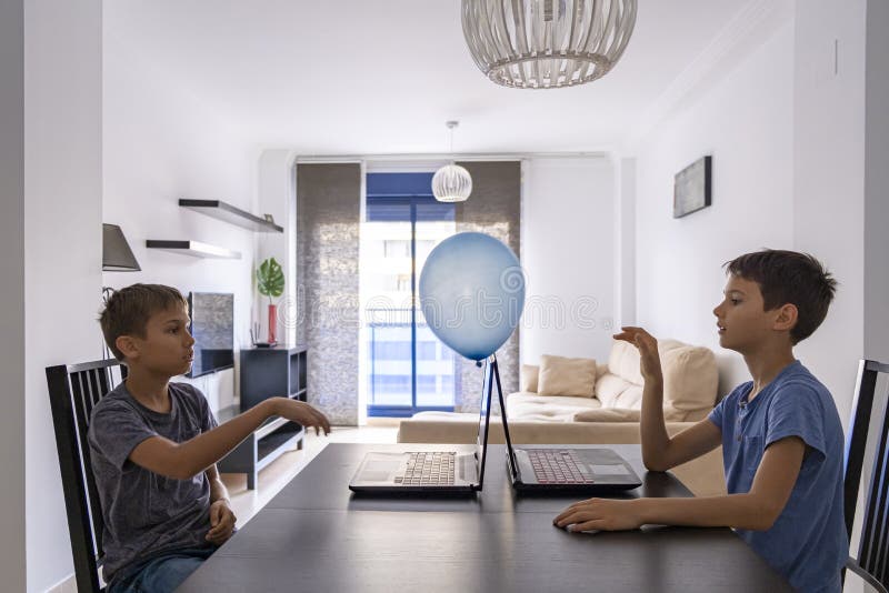 Children learning with laptop computer and play with balloon at home. Technology, education, online distance learning