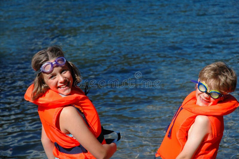 Children in lifejackets by the sea