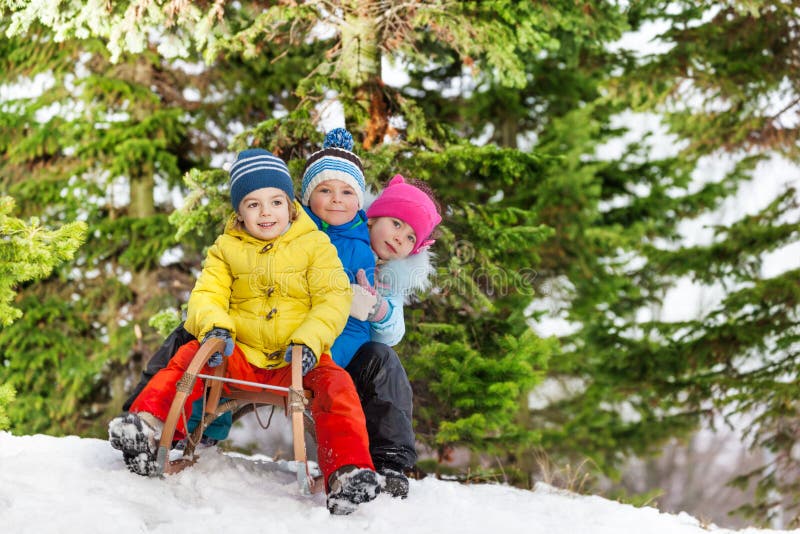 Children little boys and girl slide on sledge