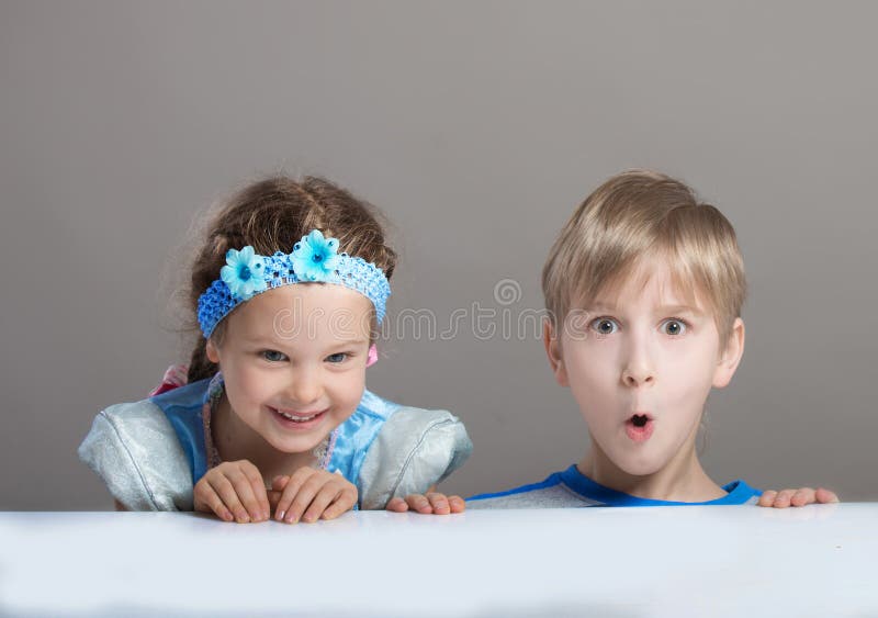 Children looking at camera from behind the table