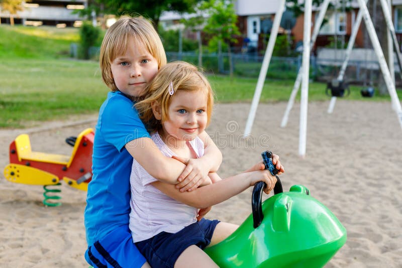 Brother Hugging Little Sister Siblings Playing Together At Playground 