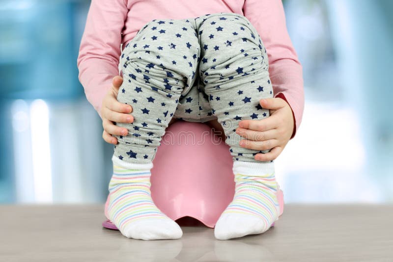 Children& x27; piernas de s que cuelgan abajo de un cámara-pote en un fondo azul imágenes de archivo libres de regalías Children& x27; piernas de s que cuelgan abajo de un cámara-pote en un fondo azul imágenes de archivo libres de regalías