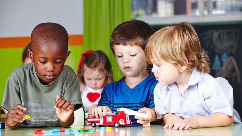 Children play together in kindergarten. Children play together with a fire brigade in kindergarten stock image Children play together in kindergarten. Children play together with a fire brigade in kindergarten stock image